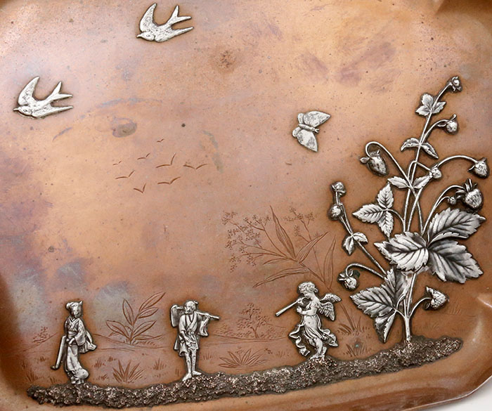 detail of silver applied to copper tray with engraved highlights