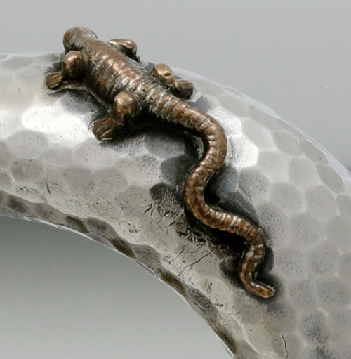 close up of applied copper salamander on the handle of pitcher